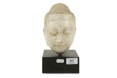 Lot 547 - A Tibetan carved marble Buddha head, raised on...