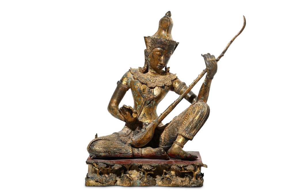 Lot 378 - A THAI GILT METAL FIGURE OF A FEMALE MUSICIAN....