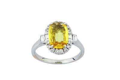 Lot 77 - A yellow sapphire and diamond cluster ring ...