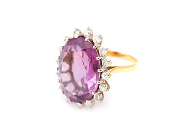 Lot 414 - An amethyst and diamond ring, Set with an oval-...