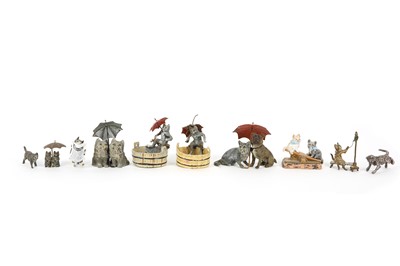 Lot 643 - A small collection of painted metal cats in...