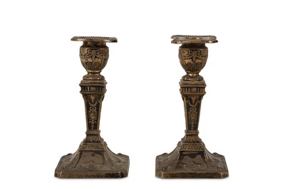 Lot 100 - A pair of Edwardian silver candlesticks in the...