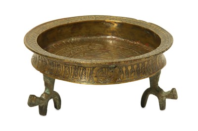 Lot 34 - AN ENGRAVED BRASS DISH WITH TRIPOD Iran, 12th -...