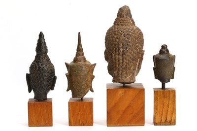 Lot 410 - FOUR BRONZE BUDDHA HEADS Cambodia and Laos,...
