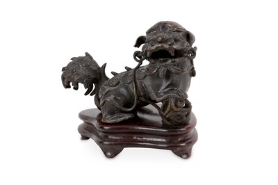 Lot 298 - A Chinese bronze lion dog, the right paw...