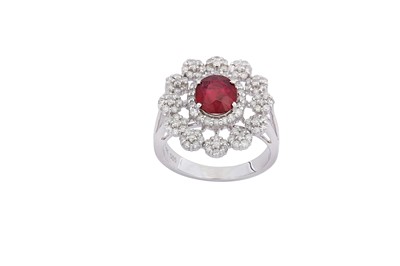 Lot 58 - A ruby and diamond cluster ring The oval-cut...