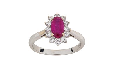 Lot 304 - A ruby and diamond cluster ring The oval-cut...