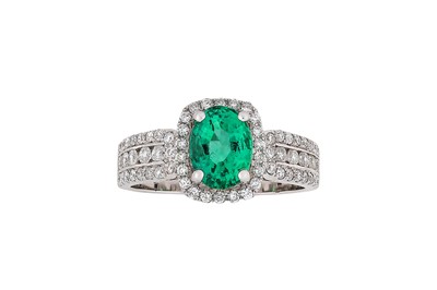 Lot 273 - An emerald and diamond ring The oval-cut...